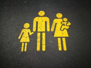 Stenciled image of family, yellow paint on concrete