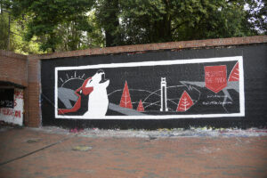 A mural at the free expression tunnel showing wolf howling in front of the bell tower and NC State scenery with the words respect the pack, equity and inclusion. Photo by Marc Hall