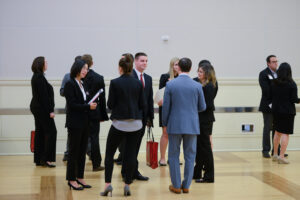 A group of professional dressed people are networking at a business event.